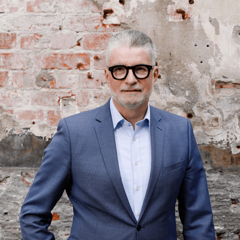 Anwalt im blauen Anzug vor alter Backsteinmauer bei pbw-Recht Bremen