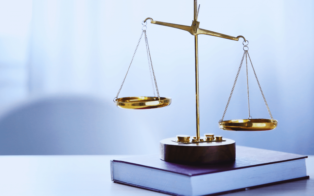 Goldene Waage auf Gesetzbuch im Büro, Symbol für Bau- und Architektenrecht